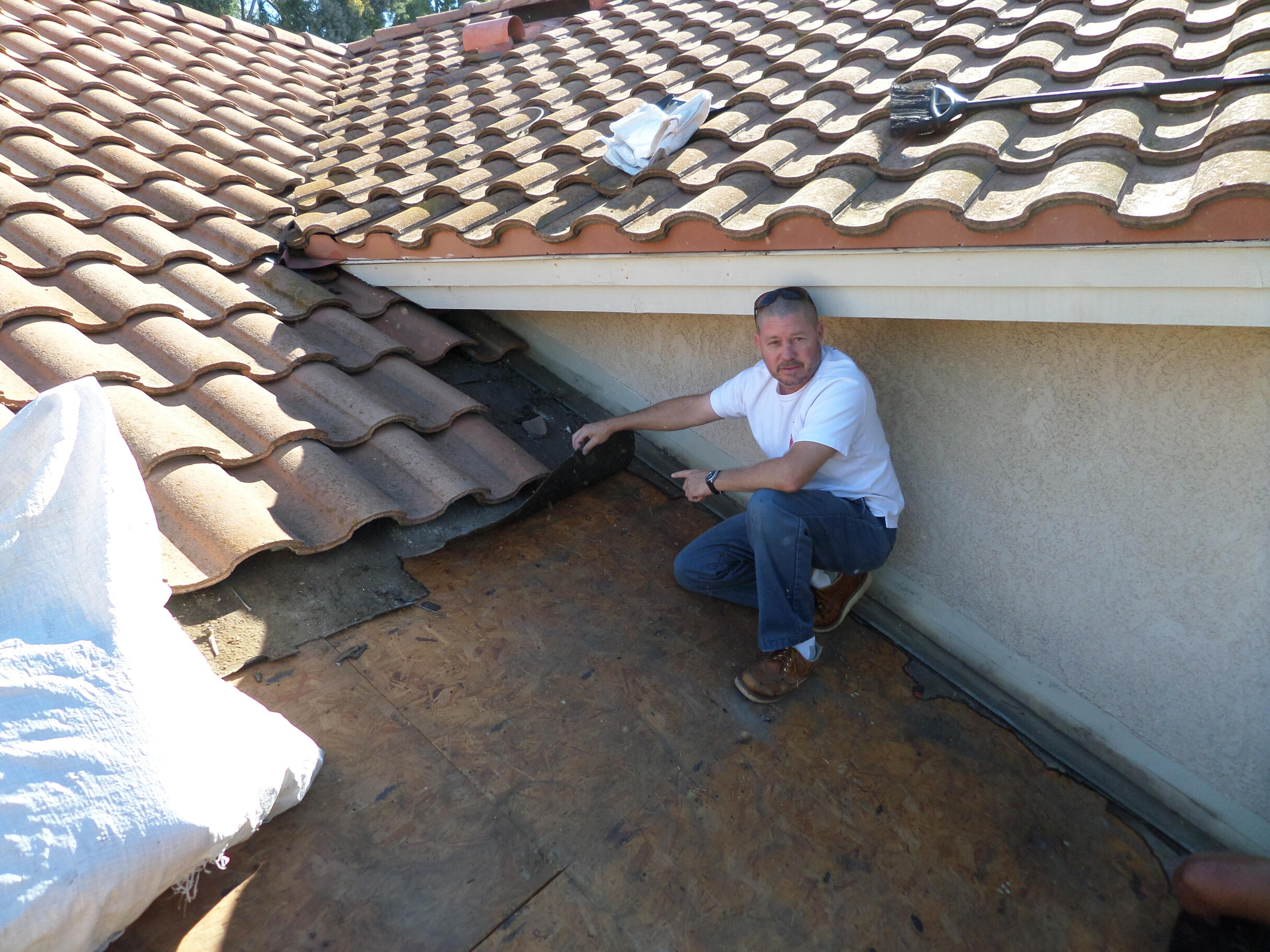 roofer pointing out a roof leak source